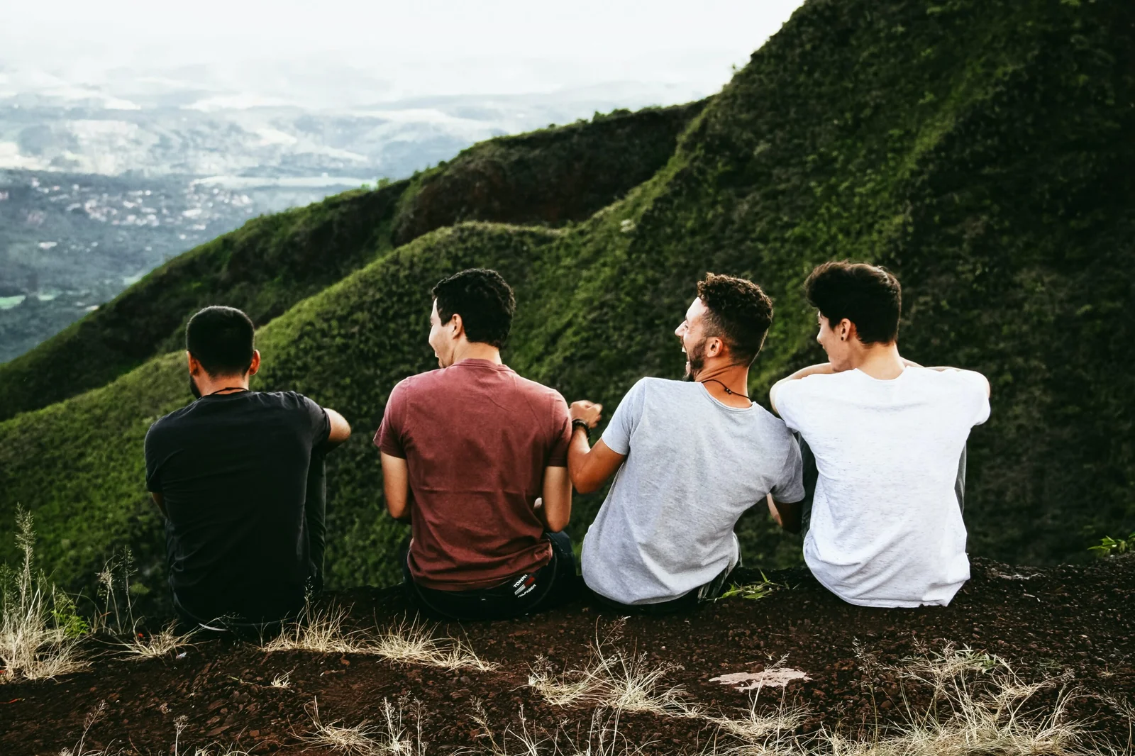 Men laughing by green valley Men laughing by green valley