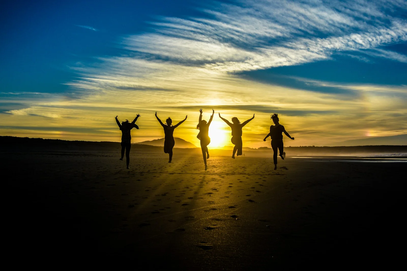 people jumping on shore front of golden hour people jumping on shore front of golden hour