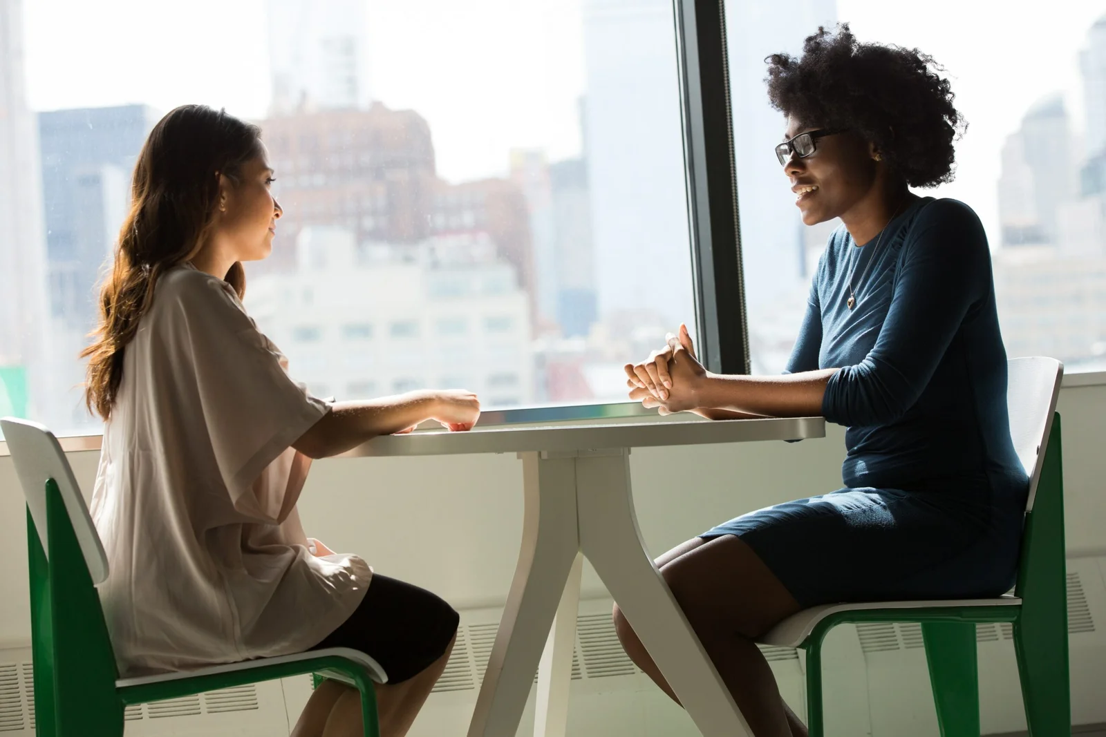 two women sitting beside table and talking two women sitting beside table and talking